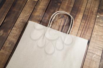 Blank craft paper bag on wooden background.