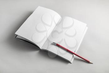 Blank book and pencil on paper background.