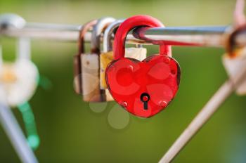 Locked red heart shaped padlock. Symbol of eternal love. Selective focus.