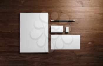 Photo of blank corporate stationery on wood table background. Branding mock-up. Flat lay.