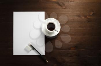 Blank stationery set on wood table background. Letterhead, coffee cup, pencil and eraser. Space for text. Flat lay.