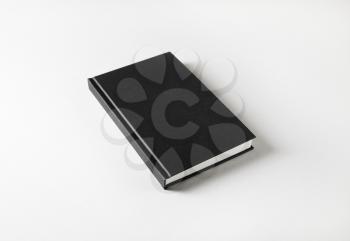 Blank black book cover on white paper background.