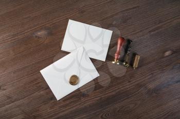 Vintage envelope with wax seal, stamp, spoon, and postcard on wooden background. Postal stationery. Flat lay.