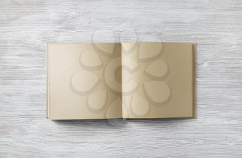 Blank kraft paper book on light wooden background. Responsive design mockup. Flat lay.