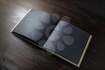 Blank black book mock up on wooden background. Template for placing your design.