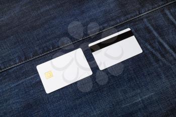 Two white blank credit cards on denim background. Chip cards. Front and back view.