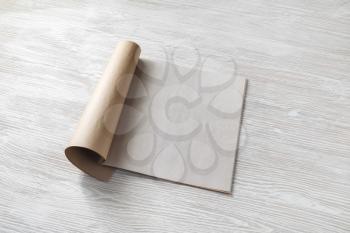 Blank magazine pages or booklet on wooden table background.