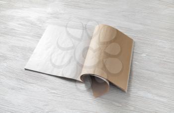 Opened blank magazine, booklet or brochure on light wooden background.