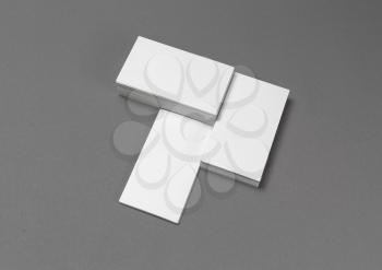 Photo of blank business cards with soft shadows on gray background. For design presentations and portfolios. Top view.