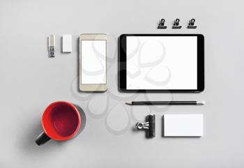 Smartphone, tablet and blank stationery on gray paper background. Brand ID template for placing your design. Top view.