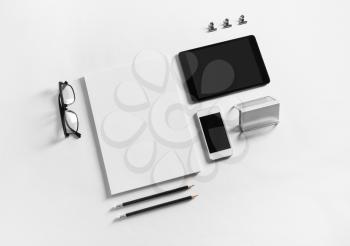 Photo of blank stationery and gadgets set on white paper background. Brand identity mockup. Top view.