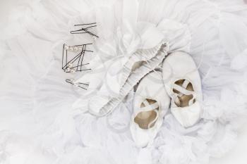 Children's ballet shoes, skirt and hairpins for hair. Still Life with white ballet accessories. Top view.