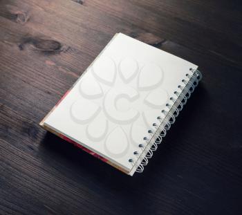 Blank spiral notebook or notepad on dark wooden background. Mockup for your design.