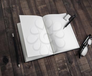 Photo of blank book and stationery on wooden background. Template for placing your design.