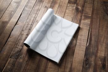 Blank magazine pages on wooden table background.
