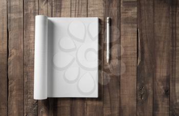 Blank opened magazine and pencil on vintage wooden table background. Flat lay.