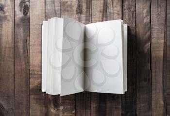 Photo of opened book with blank pages on wooden background. Top view.