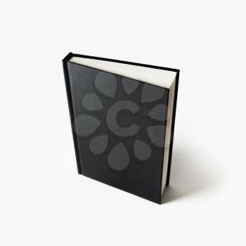 Black hardcover book on white paper background. Blank notebook.