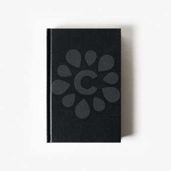 Blank black booklet. Vertical book cover on white paper background. Flat lay.
