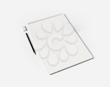 Blank notebook, pen and eraser on white paper background. Notepad and stationery.