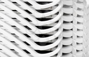 Stacked white plastic beach loungers. Abstract background.