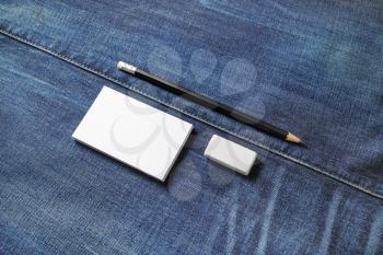 Blank stationery set. White business cards, pencil and eraser on denim background.