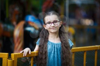 Portrait of a smiling child girl with long wavy hair outdoors. Selective focus.