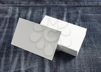Photo of blank white business cards on denim background.