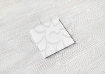 Blank square brochure on light wooden background. Responsive design template.