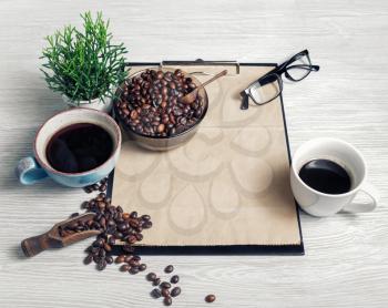 Still life with coffee and clipboard on light wood table background.