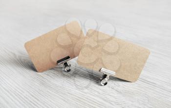 Photo of blank kraft paper business cards on light wood table background. Copy space for text.