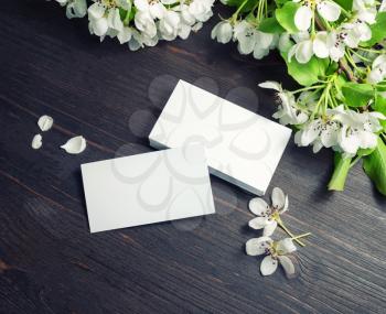 Blank business cards template and flowers on wooden background. Template for graphic designers portfolios.