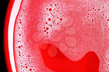 Soap foam with bubbles on bright red background. Soap sud in water. Flat lay.