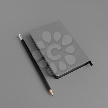 Blank notebook and pencil on gray paper background. Template for branding identity.
