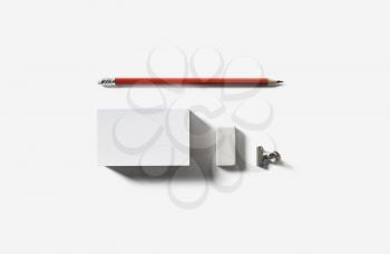 Blank white business card, pencil and eraser. Top view. Flat lay.