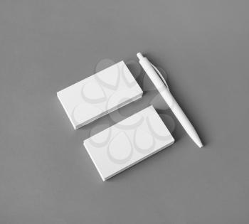 Blank stationery set. White business cards and pen on gray background.