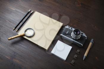 Photo of blank vintage stationery and retro camera on wooden background. Responsive design template.