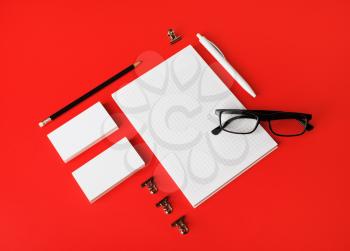 Blank stationery set on red paper background. Template for branding identity. For graphic designers presentations and portfolios.