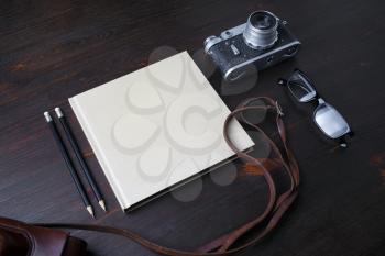 Vintage stationery and retro photo camera on wooden background.