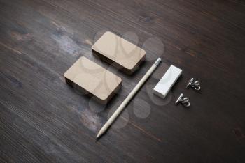 Blank stationery mockup. Kraft business cards, pencil and eraser on wooden background. Brand ID set.
