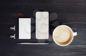 Branding mock up. Coffee cup, smartphone, blank business card and pen on wooden background. Top view. Flat lay.