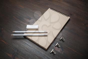 Blank kraft notepad, pencils and eraser on wood table background.