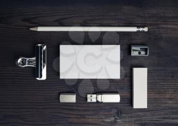 Blank stationery set on wooden background. Business card, pencil, eraser and flash drive. Top view. Flat lay.