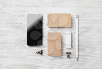 Blank stationery set and smartphone on light wood table background. Branding mock up. Flat lay.