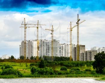 Horizontal contruction cranes on building site background