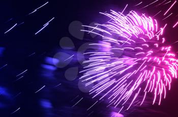 Dramatic pink and purple fireworks at night sky background
