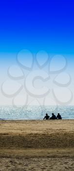 Vertical three freinds sitting on the ocean beach background backdrop