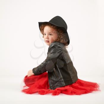 Little girl with black hat sitting and dreaming