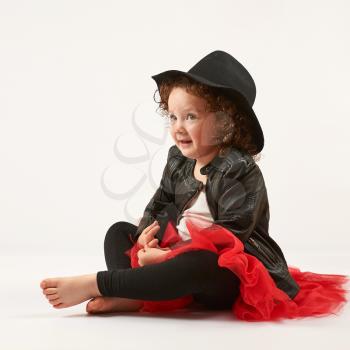 Little girl with black hat sitting and dreams