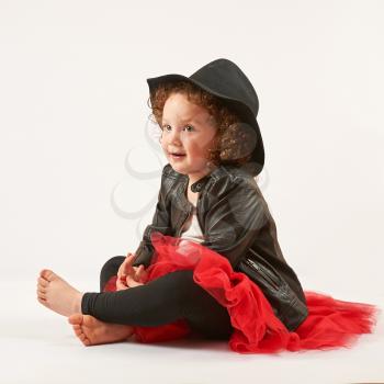 Little girl with black hat sitting and dreams